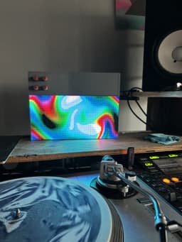 A rainbow pattern on Nick's Patternflow, on the shelf above a turntable