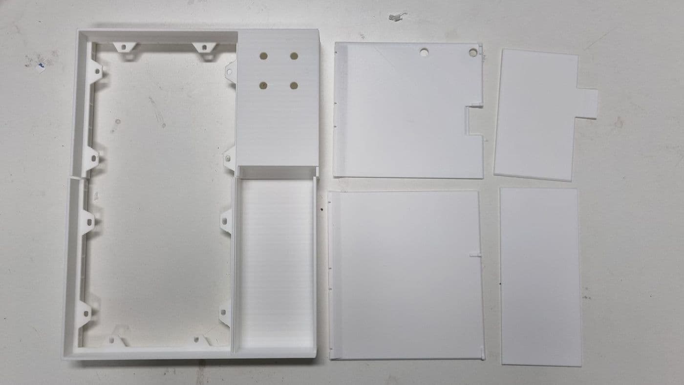 Everything from the 256 mm print laid out before gluing: the two frame halves, the back-panel halves and the covers, all in white