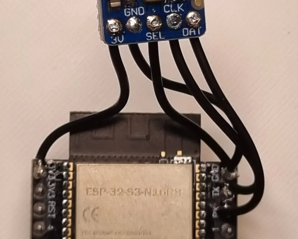 Five black leads run from the microphone breakout's pads down to the ESP32 module's header pins: one to 3V3 at the top of the left pin row, two to GND, and one each to TX and RX at the top of the right row.